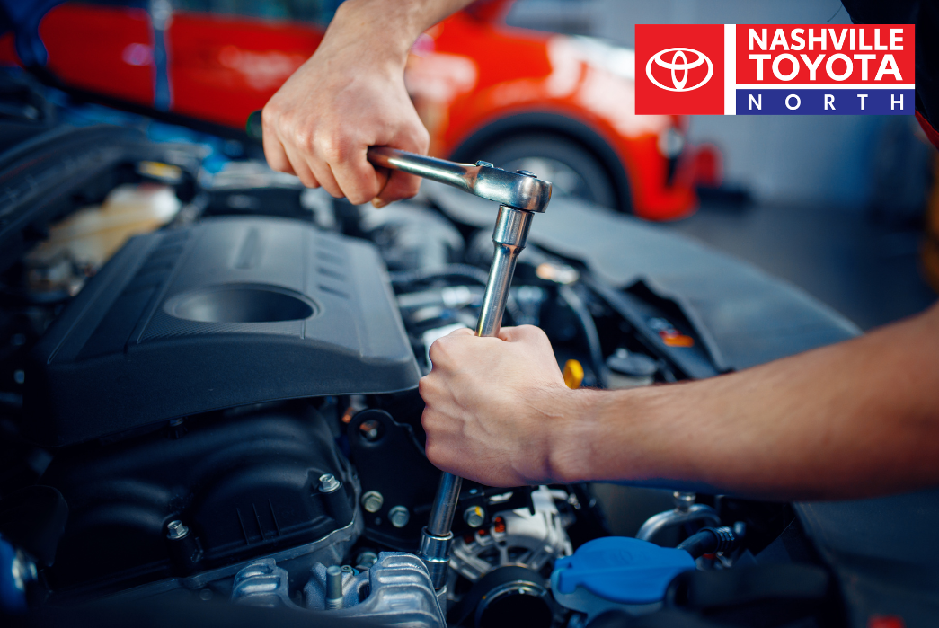 An individual is working on the engine of a car.