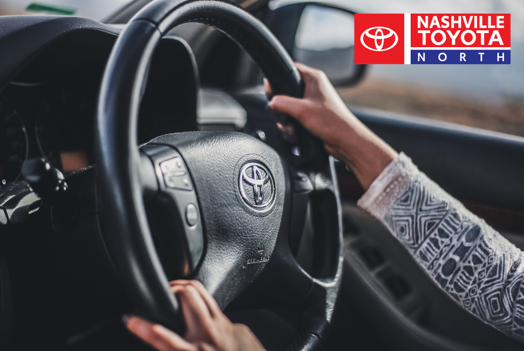 a person driving a car with their hands on the steering wheel