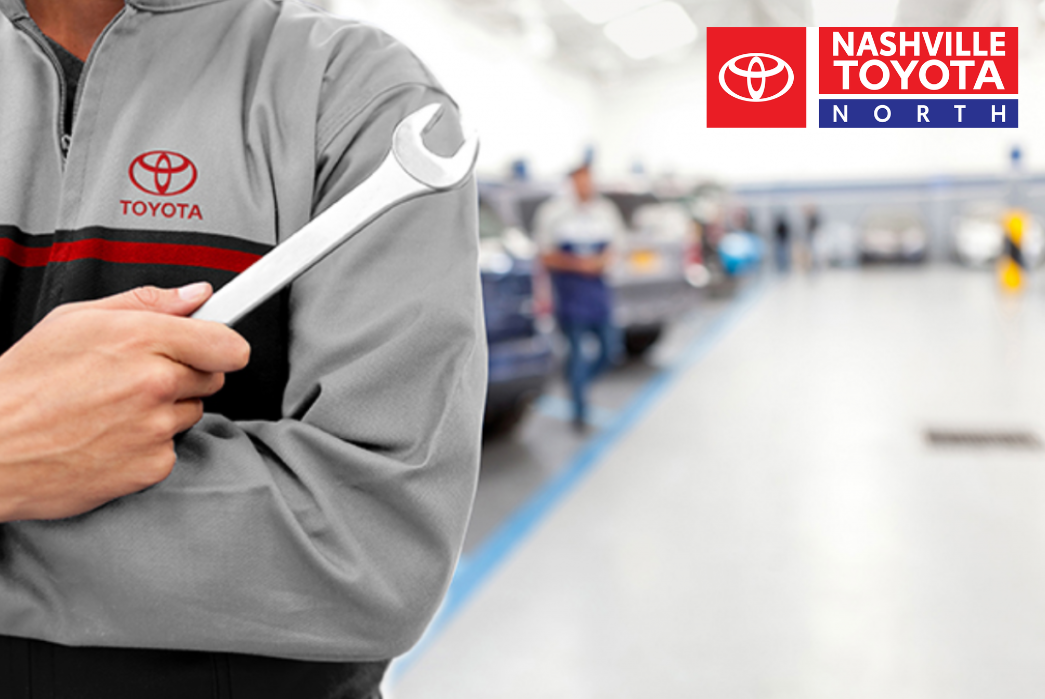 A person holding a wrench in a Toyota service center
