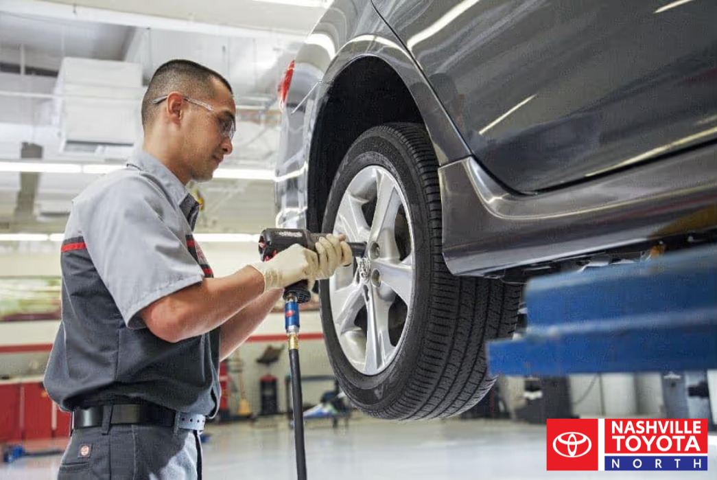 A person is working on the tire of a car