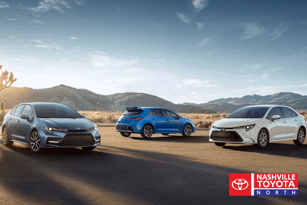 Three Toyota Corolla cars in different colors—blue, bright blue, and white—parked on a desert road with mountains in the background.